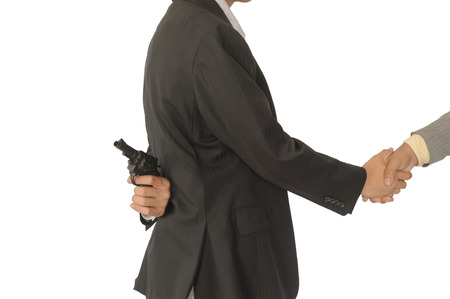 Behind the two businessmen holding a gun,Concepcion dishonesty in business.Isolate on white.の写真素材