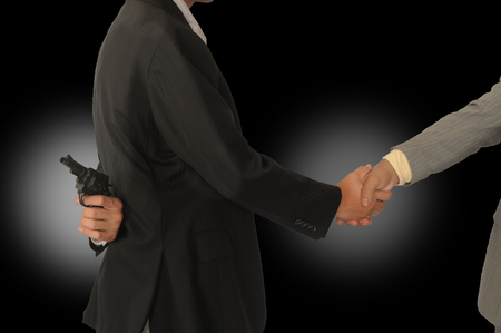 Behind the two businessmen holding a gun,Concepcion dishonesty in business.の写真素材
