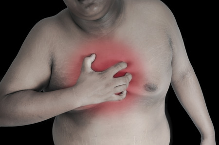 Fat man chest pain because of obesity on a black background.Red Symbol of Pain.の写真素材