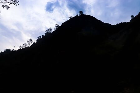 blue clouds on the background with a mountain in front. silhouetteの写真素材