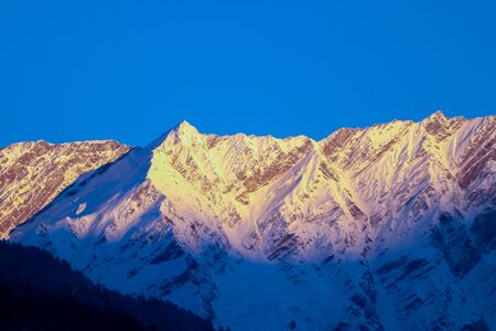 sunrise on the top of a snow-covered mountain.の写真素材