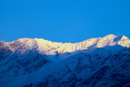 sunrise on the top of a snow-covered mountain.の写真素材