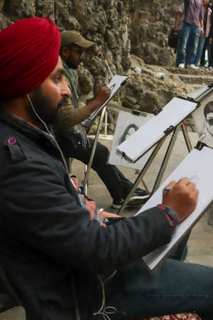 01 Janurary â2019, Rock Garden, Chandigarh, Punjab. A person drawing a sketch of girl on white paper with a pencil on white paper at Rock Garden, Chandigarh, Punjab, Indiaのeditorial素材