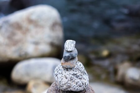 Rock Balancing: Stone Stacking Art having flowing river in the backgroundの写真素材