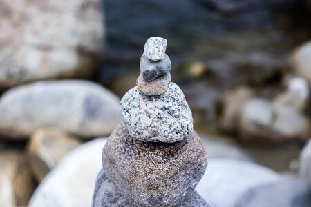 Rock Balancing: Stone Stacking Art having flowing river in the backgroundの写真素材
