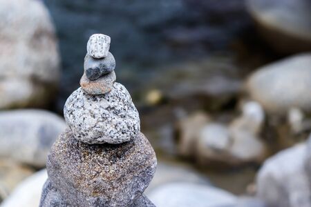 Rock Balancing: Stone Stacking Art having flowing river in the backgroundの写真素材