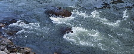flowing river having rocks in the middleの写真素材