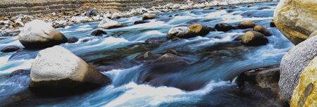 long exposure of fast flowing river having rocks in itの写真素材