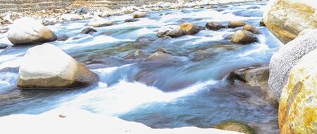 long exposure of fast flowing river having rocks in itの写真素材