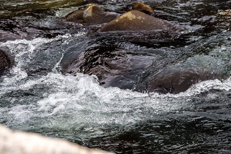long exposure of fast flowing river having rocks in itの写真素材