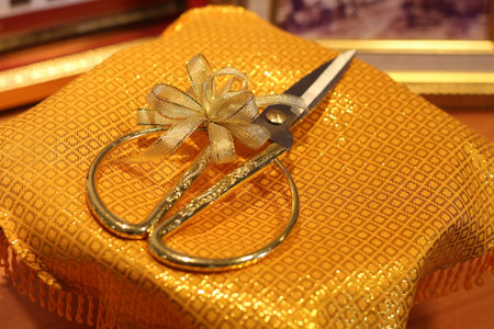 Scissors tied with ribbon on gold satinの写真素材