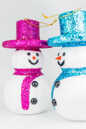Pink and blue snowmans on white backgroundの写真素材