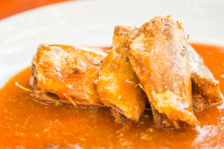 Canned fish in tomato sauce on white plateの写真素材