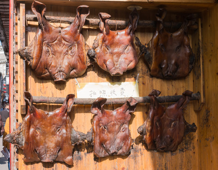 Smoked dry skin pig head hanging in the shop in Feng huang, Hunan, Chinaの写真素材