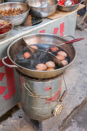 Boiled eggs in herbal soup, street food in Feng huang, Hunan, Chinaの写真素材