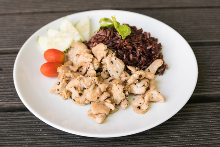 Chicken stir fried with garlic and pepper served with brown riceの写真素材