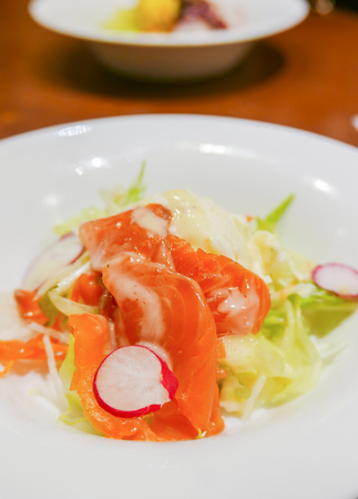 Japanese Salad - Salmon with Fresh Fruit , Vegetables and dressing on white plateの写真素材