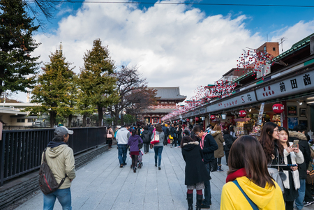Tokyo, Japan - Nov 30, 2015: Crowds of visitors browsing the colourful market stalls of Nakamise-dori the popular destination leading to Senso-ji temple in the Asakusa district of downtown Tokyo, Japan./ Crowds of visitors browsing the colourful market stのeditorial素材