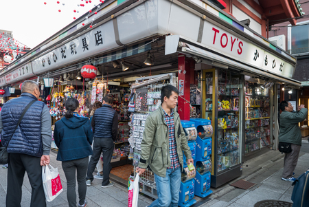 Tokyo, Japan - Nov 30, 2015: Crowds of visitors browsing the colourful market stalls of Nakamise-dori the popular destination leading to Senso-ji temple in the Asakusa district of downtown Tokyo, Japan./ Crowds of visitors browsing the colourful market stのeditorial素材