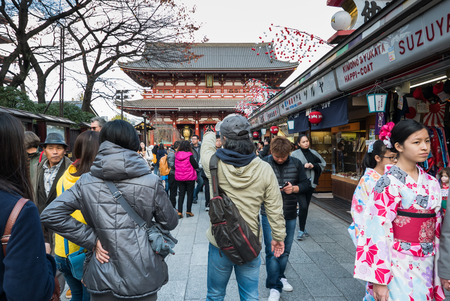 Tokyo, Japan - Nov 30, 2015: Crowds of visitors browsing the colourful market stalls of Nakamise-dori the popular destination leading to Senso-ji temple in the Asakusa district of downtown Tokyo, Japan./ Crowds of visitors browsing the colourful market stのeditorial素材