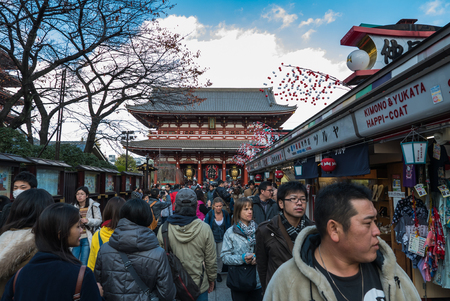 Tokyo, Japan - Nov 30, 2015: Crowds of visitors browsing the colourful market stalls of Nakamise-dori the popular destination leading to Senso-ji temple in the Asakusa district of downtown Tokyo, Japan./ Crowds of visitors browsing the colourful market stのeditorial素材
