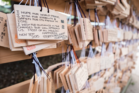 Tokyo, Japan - November 30, 2015: People write their wish on a wooden board (ema) and leave that at the Meiji Shrine, a Shinto complex in Tokyo dedicated to the Emperor Meiji and his wife, Empress ShÅken. Completed in 1926, it is situated in 175 acres ofのeditorial素材