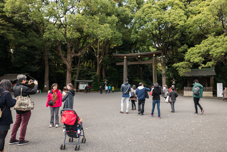 Tokyo, Japan- november 30, 2015 Torii gate at the entrance of Meiji-jingÅ« with people passing by.のeditorial素材