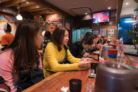 Tokyo, Japan - November 30, 2015: Costomer waiting for Ramen in a Ramen restaurant in Harajuku, Tokyo.のeditorial素材
