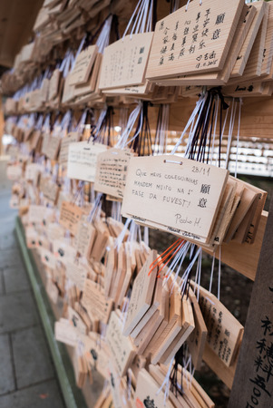 Tokyo, Japan - November 30, 2015: People write their wish on a wooden board (ema) and leave that at the Meiji Shrine, a Shinto complex in Tokyo dedicated to the Emperor Meiji and his wife, Empress ShÅken. Completed in 1926, it is situated in 175 acres ofのeditorial素材