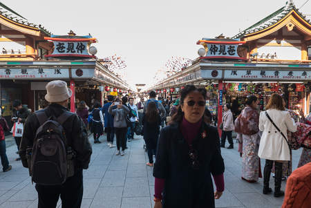 Tokyo, Japan - Nov 30, 2015: Crowds of visitors browsing the colourful market stalls of Nakamise-dori the popular destination leading to Senso-ji temple in the Asakusa district of downtown Tokyo, Japan./ Crowds of visitors browsing the colourful market stのeditorial素材