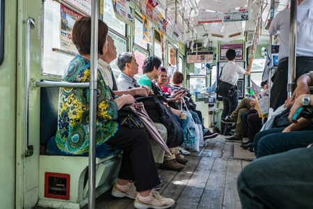 KUMAMOTO, JAPAN - SEPTEMBER 27, 2014: Inside the classic tram of Kumamoto city at the tram stop near Kumamoto castle in Kumamoto, Kyushu , Japan. Team is the easiest way to access tourist spot in Kumamoto city is by using local trams service.のeditorial素材