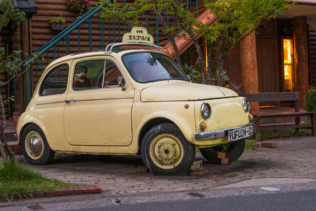 Yufuin, Japan - September 28, 2014: A yellow car near the shopping street of Yufuin in Oita, Japan. Yufuin was a town located in Oita District, Oita Prefecture, Japan. Yufuin is now a district within the city of Yufu.のeditorial素材