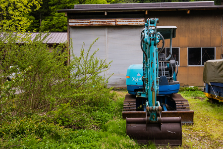 Shirakawa-go, Japan - May 3, 2016: Blue backhoe in Shirakawa-go. Shirakawa-go is one of Japan's UNESCO World Heritage Sites located in Gifu Prefecture, Japan.のeditorial素材