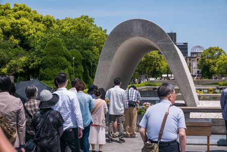Hiroshima, Japan - May 5, 2016: Tourists pay their respects to Cenotaph for the A-bomb Victims at Hiroshima Peace Memorial Park. Hiroshima Peace Memorial Park  is a memorial park in the center of Hiroshima, Japan. It is dedicated to the legacy of Hiroshimのeditorial素材
