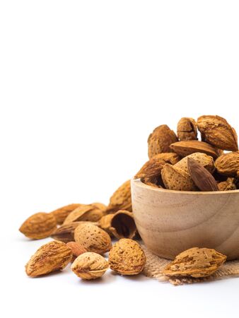 Almonds in wooden bowl on white backgroundの写真素材