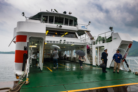 Hiroshima, Japan - May 6, 2016: Tourist boarding to ferry at Matsudai Kisen ferries (JR ferry-port) crossing the inland sea between Miyajimaguchi and Miyajima .The Ferries carry visitors to the Itsukushima Shrine on island.のeditorial素材