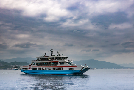 Hiroshima, Japan - May 6, 2016: Matsudai Kisen ferry crossing the inland sea between Miyajimaguchi and Miyajima island. The Ferries carry visitors to the Itsukushima Shrine on island.のeditorial素材