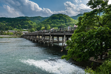 Kyoto, Japan - May 7, 2016: Togetsu-kyo Bridge in Arashiyama district, Kyoto, Japan. The Togetsu-kyo Bridge has been a landmark in Western Kyoto's Arashiyama District. The wooden bridge spans the Katsura River in front of Arashiyama Mountain, offering incのeditorial素材