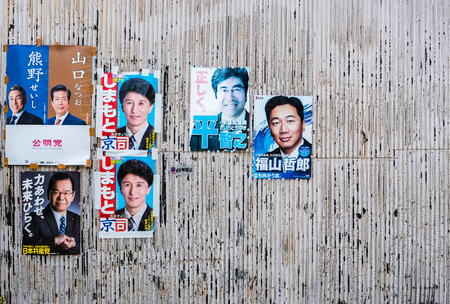 Kyoto, Japan - May 8, 2016: Politicians on a political campaign poster on the old galvanized iron wall.のeditorial素材