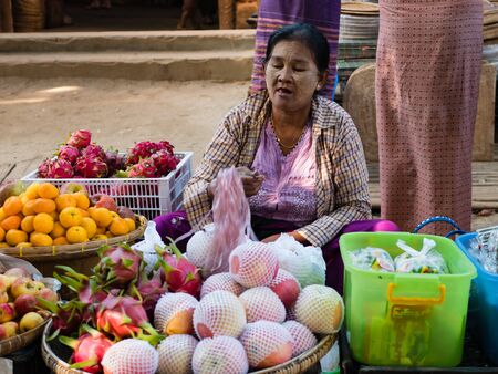 Bagan , Myanmar - October 21, 2016: Burmese woman selling fresh fruit at Mani Sithu Market in Nyaung-U village, Bagan, Myanmar (Burma)のeditorial素材