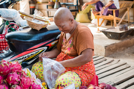 Bagan , Myanmar - October 21, 2016: Burmese woman selling fresh fruit at Mani Sithu Market in Nyaung-U village, Bagan, Myanmar (Burma)のeditorial素材