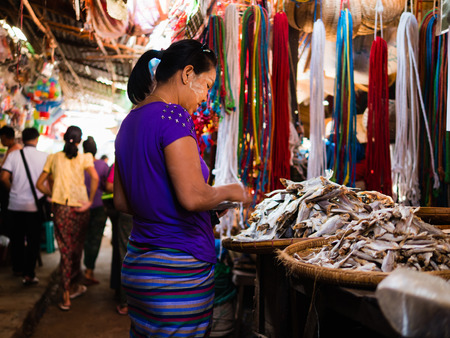 Bagan , Myanmar - October 21, 2016: Burmese woman choosing dried fish at Mani Sithu Market in Nyaung-U village, Bagan, Myanmar (Burma)のeditorial素材