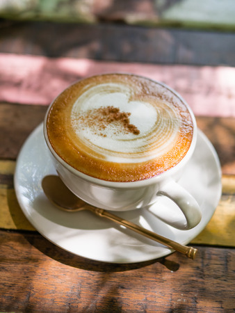 Cup of hot Cappuccino coffee close up on the wooden tableの写真素材
