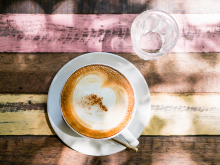 Cup of hot Cappuccino coffee close up on the wooden tableの写真素材