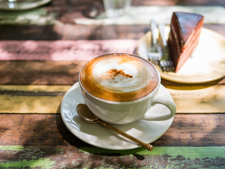 Cup of hot Cappuccino coffee close up on the wooden tableの写真素材