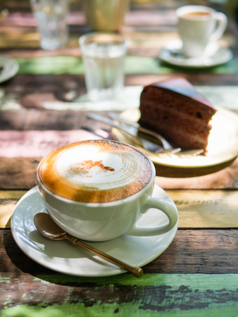 Cup of hot Cappuccino coffee close up on the wooden tableの写真素材