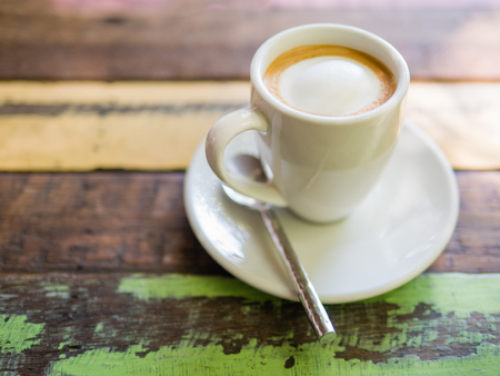 Glass of hot Latte macchiato coffee close up on the wooden tableの写真素材