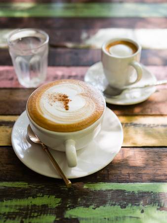 Cup of hot Cappuccino coffee close up on the wooden tableの写真素材