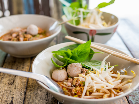 Thai food - Thai style spicy Tomyam noodle soup, famous Thai noodle soup on wooden table, selective focus.の写真素材