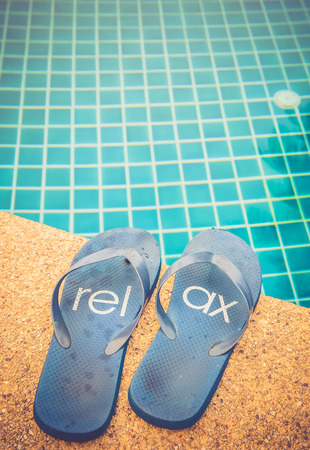 Summer background with Relax flip flops near the swimming poolの写真素材